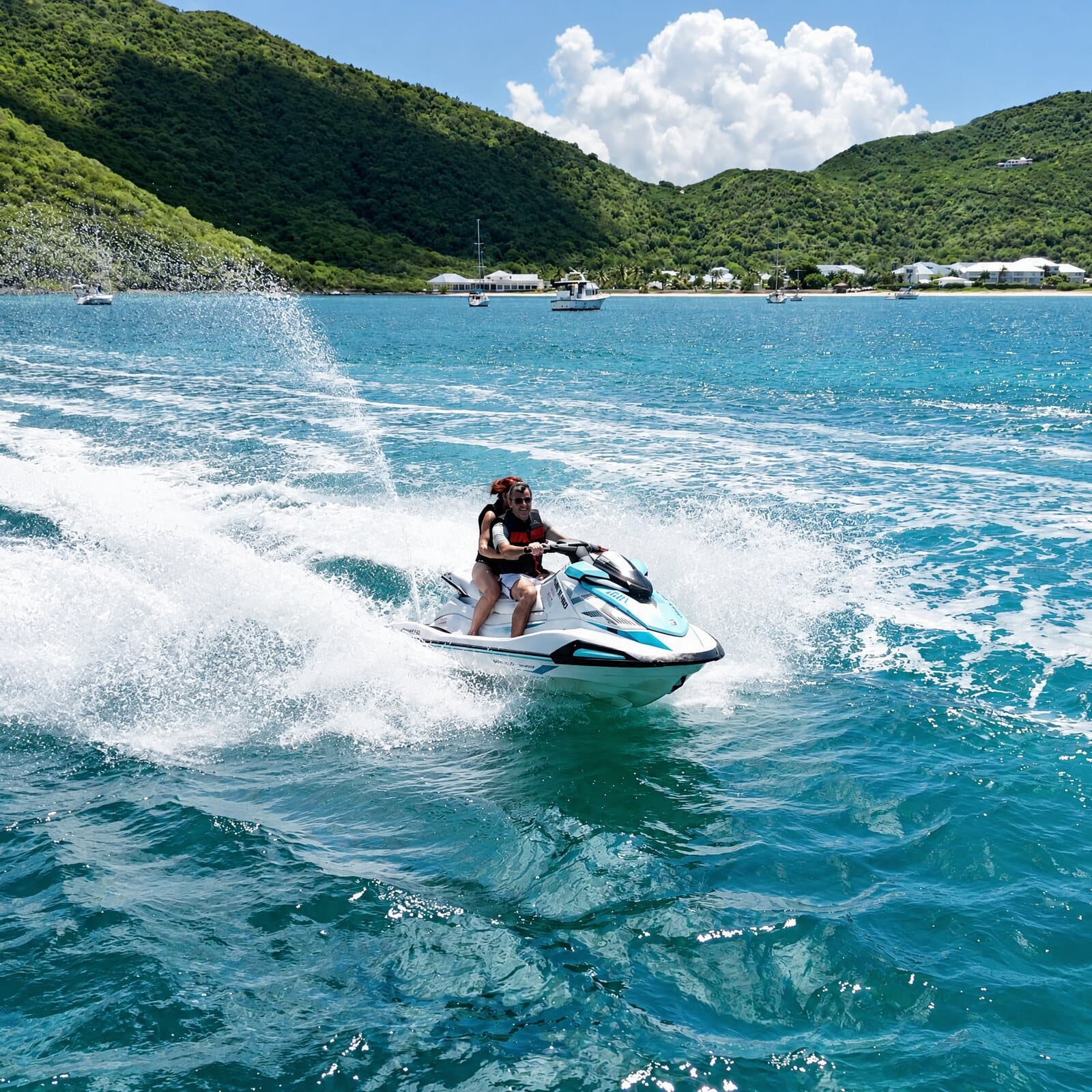 Two people on a jet ski carving through a burst of spray, below the hills of Anse Marcel