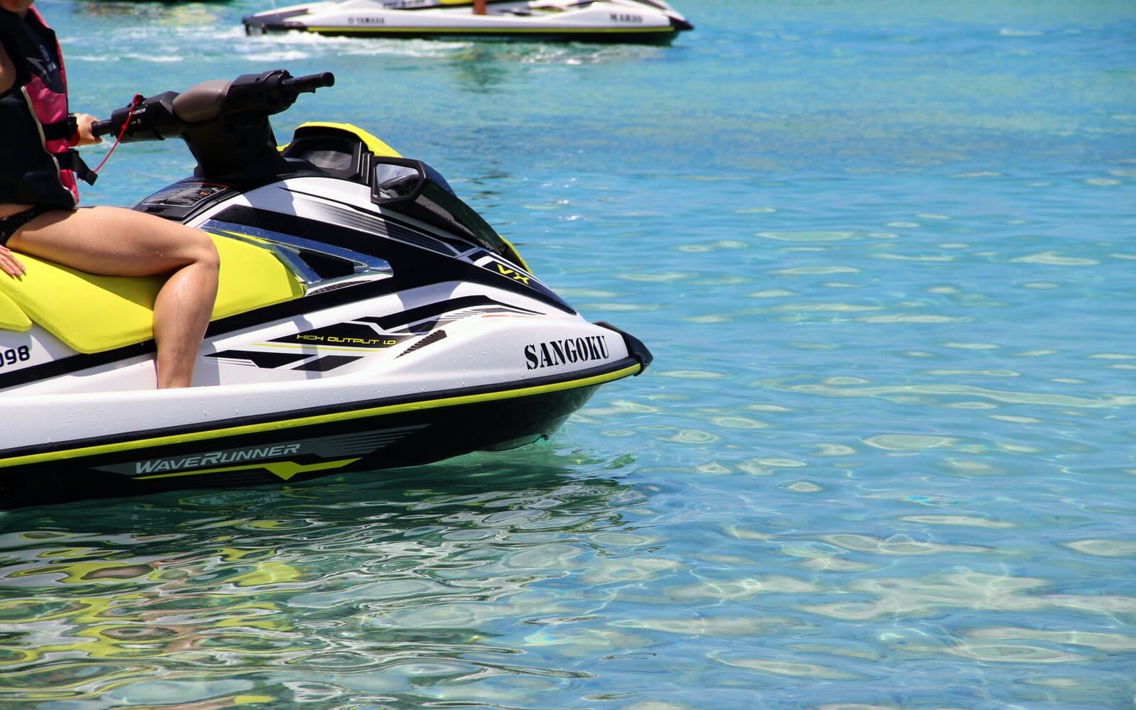 A jet ski at rest in water so clear you can see the bottom