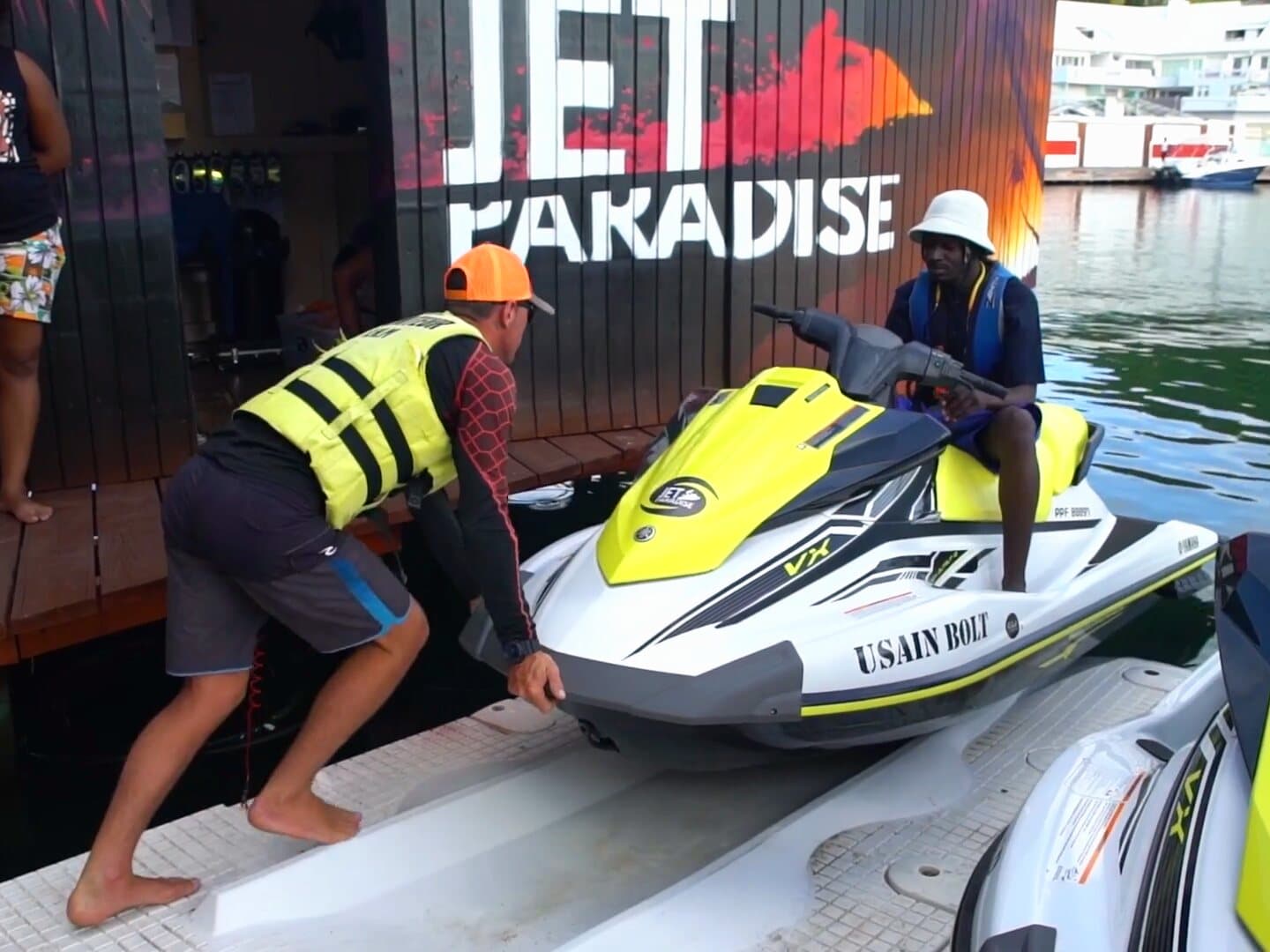 A guide pushes a jet ski along the pontoon, in front of the Jet Paradise shop