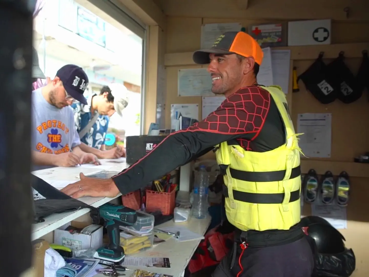 En el mostrador de Jet Paradise, un instructor atiende a unos clientes que completan su ficha