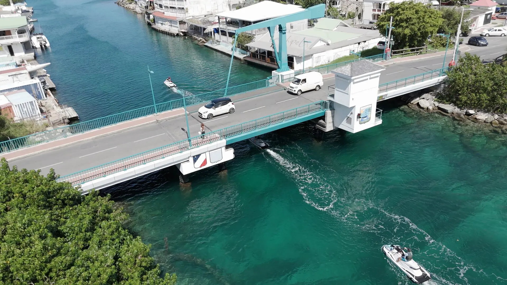El puente de Sandy Ground en Marigot visto desde el cielo: autos en la carretera y jet skis por debajo